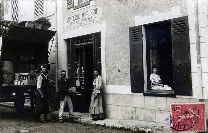 Émile (à gauche), Louise et Émilienne, 18 ans au 7, rue de Culoisel qui devient la rue de Mantes (peu après 1906), puis l’actuelle rue Paul Doumer (autour de 1934). Aux nos 5-7 se trouve de nos jours la bibliothèque municipale de Vernouillet. ID655 01 Boutique